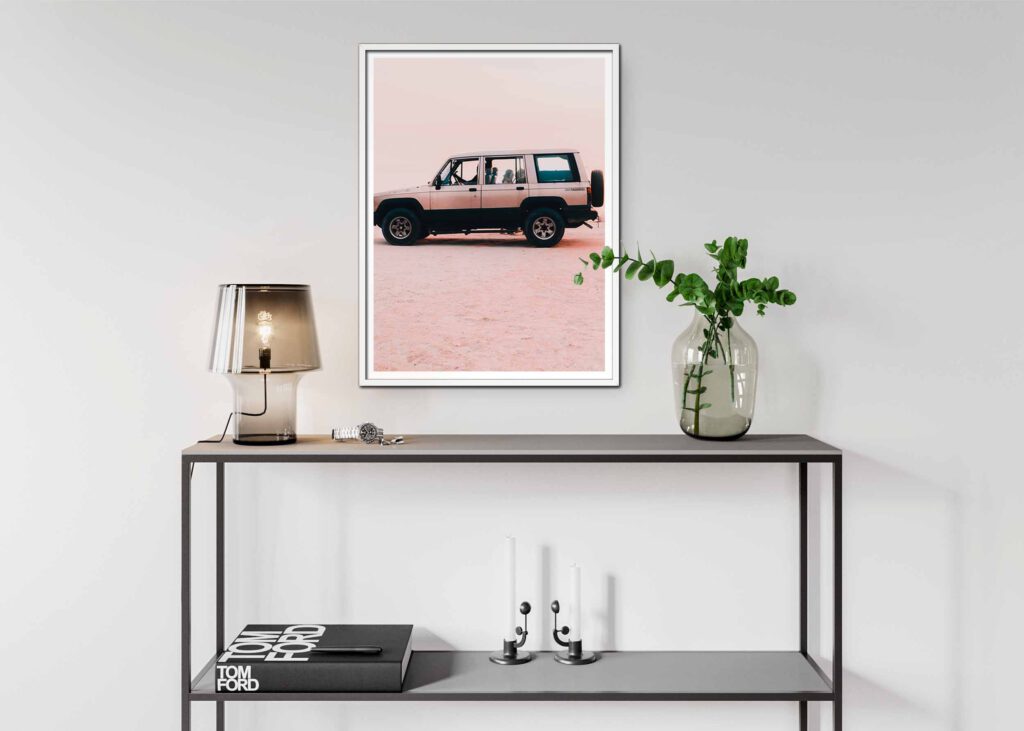 Poster som visar en beige Isuzu Trooper står parkerad på en rosa sandöken under en klar himmel.